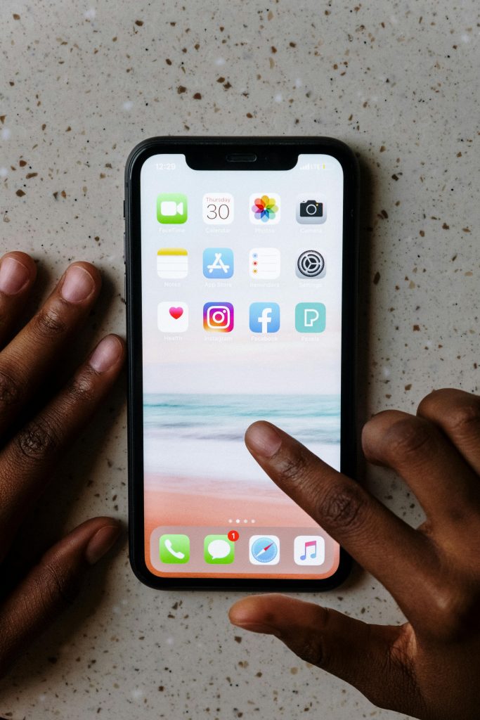 Hands interacting with smartphone apps on a table.